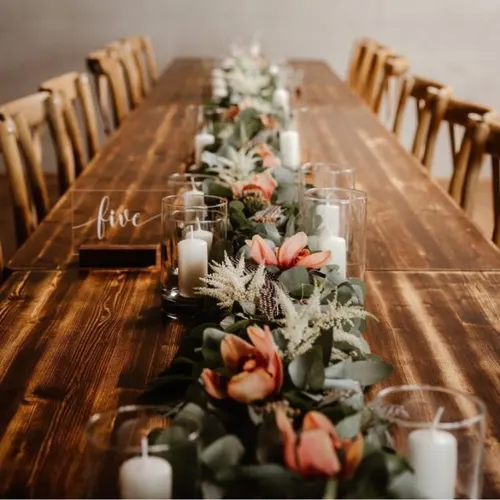 Lange Vintagetafel mit Eukalyptus, Tulpen, Kerzen und Tischnummer five